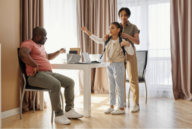 Parents helping their daughter prepare for school at home
